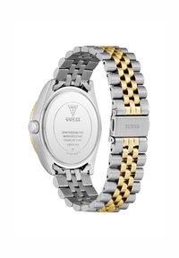 Montre en acier inoxydable argent et doré, avec un mélange de maillons brossés et brillants, dotée d'un boîtier rond et d'une fermeture sécurisée. Résistante à l'eau jusqu'à 50 mètres.