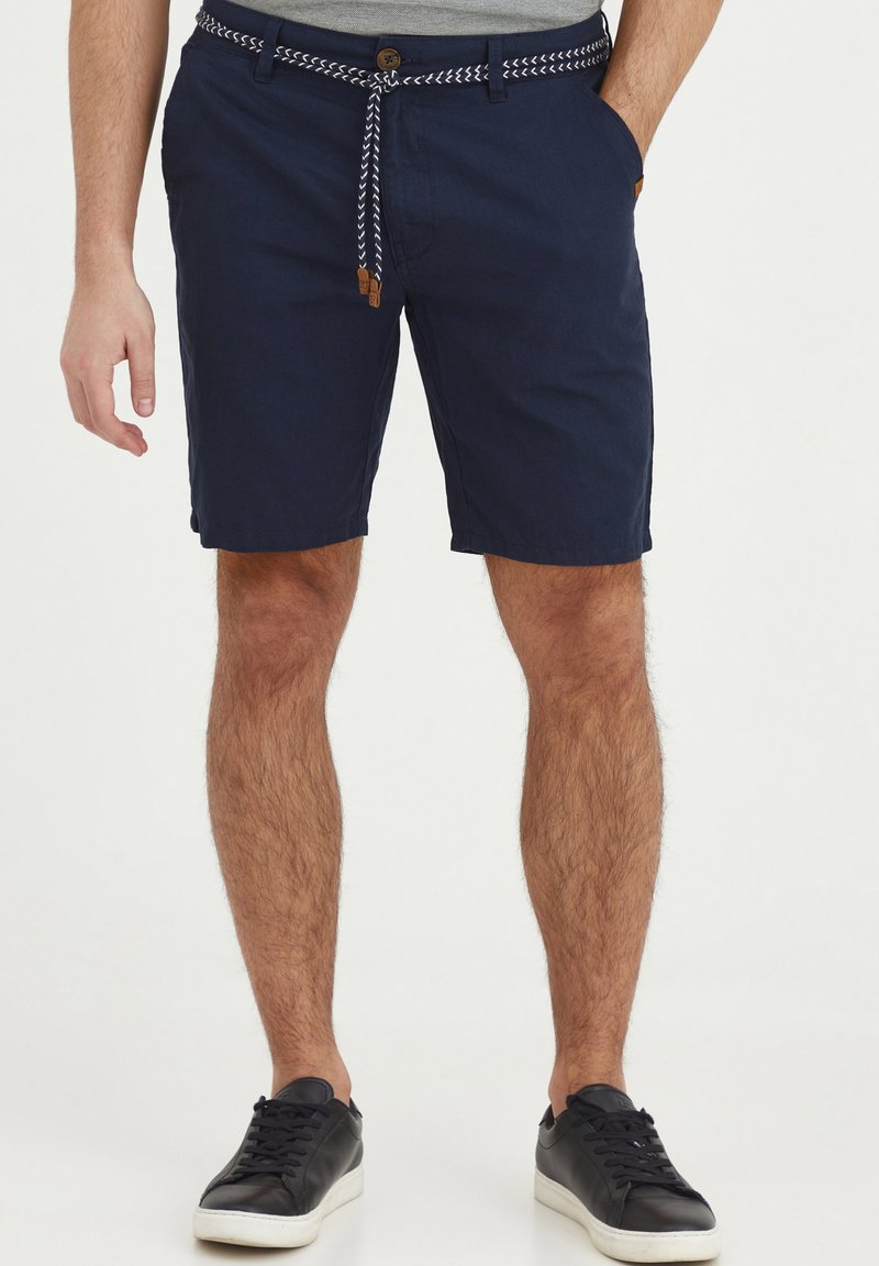 Navy blue shorts with a woven white drawstring, button closure, and side pockets. Fabric appears lightweight and casual.