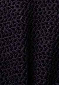 Tissu tricoté de couleur violet foncé avec un motif ajouré texturé, présentant une apparence douce et chaleureuse.