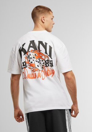 White cotton t-shirt featuring a large graphic on the back with the word "KANI," dice, flames, and "Double or Nothing" in orange and black.
