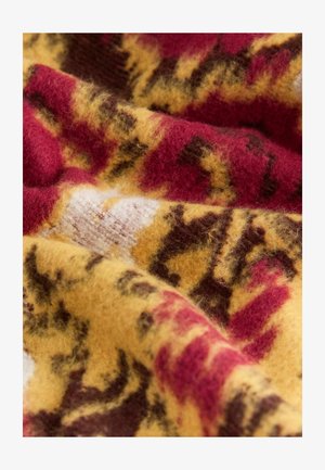 Tela de lana con una paleta de colores cálidos en tonos rojos, amarillos y marrones, con una superficie suave y texturizada que exhibe un patrón abstracto audaz.