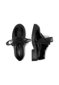Zapatos de charol negro con punta redonda, con cordones de cinta negra translúcida y suela gruesa de goma. Textura lisa y diseño plano.