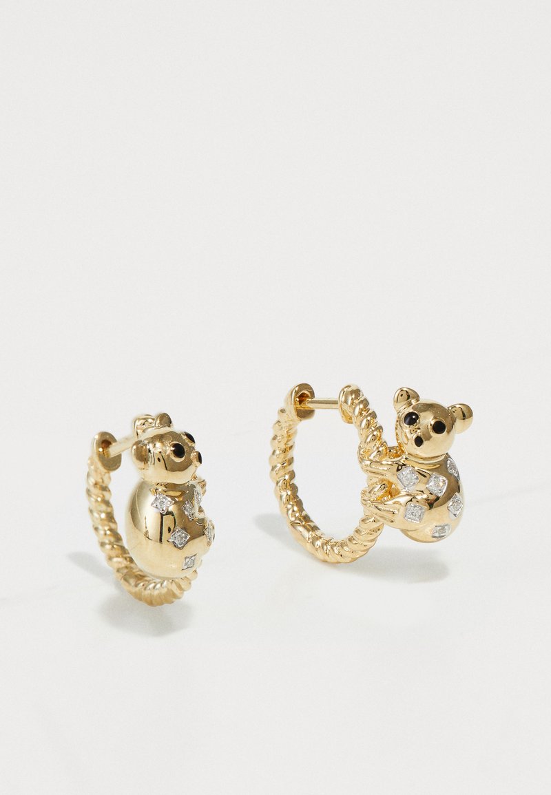 Guldörhängen med ett björndesign, dekorerade med små klara stenar, med en vriden repstruktur och böjd form.