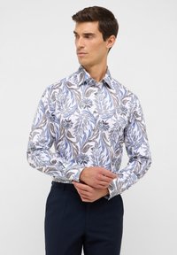 Witte overhemd met een blauw en bruin bloemenpatroon, lange mouwen, button-down kraag en contrasterende knopen. In combinatie met donkere broeken.