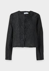 Black cropped jacket with a textured surface, featuring long sleeves and five toggle fastenings at the front. Simple round neckline.
