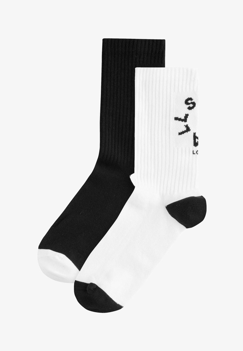 Fekete-fehér pamut zoknik bordás textúrával, kontrasztos színekkel és grafikus logóval a fehér zoknin.