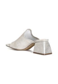Mules beige in suede con punta aperta, dotate di un tacco a blocco basso con accenti metallici e una fodera interna liscia, caratterizzate da un design senza cuciture e una leggera lucentezza.