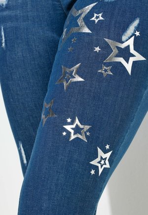 Jeans in denim blu scuro con motivi a stelle argentate e dettagli argentati. Include dettagli usurati sul tessuto per un maggiore interesse visivo.