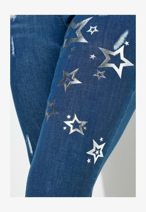 Donkere blauwe spijkerbroek met zilveren sterrenpatronen en accenten. Voorzien van verouderde details in de stof voor extra visuele uitstraling.