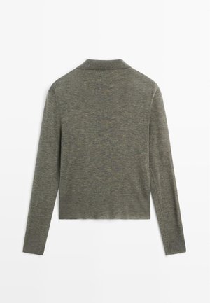 Groene, langwerpige cardigan van zacht, lichtgewicht materiaal. Heeft een sjawl kraag en een rechte snit zonder zichtbare sluitingen.