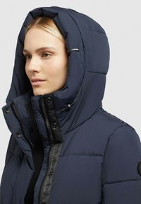 Gevoerde marineblauwe hoodie met een volledige rits en knoopsluiting, met een gestructureerde stof en een verstelbare capuchon.