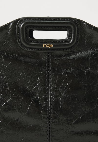 Borsa a mano in pelle nera con finitura testurizzata, caratterizzata da una maniglia rettangolare ritagliata e dettagli cuciti. Logo dorato "maje" come decorazione.