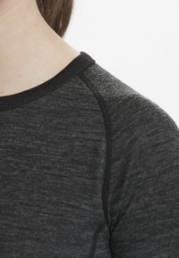Donkergrijze, gestructureerde stof T-shirt met een zwarte ribgebreide ronde hals en raglanmouwen, met een gladde, lichte uitstraling.