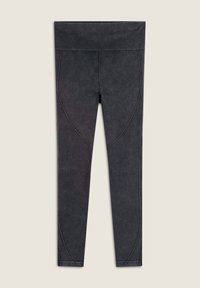 Leggings neri realizzati in tessuto testurizzato, con una cintura ampia e dettagli di cuciture curve lungo i lati.