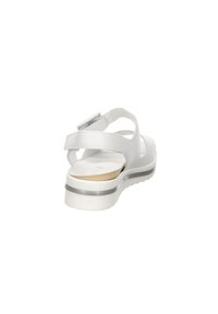 White sandals featuring a textured upper, adjustable straps, and a low heel with a gray accent. The sole is cushioned and textured for grip.