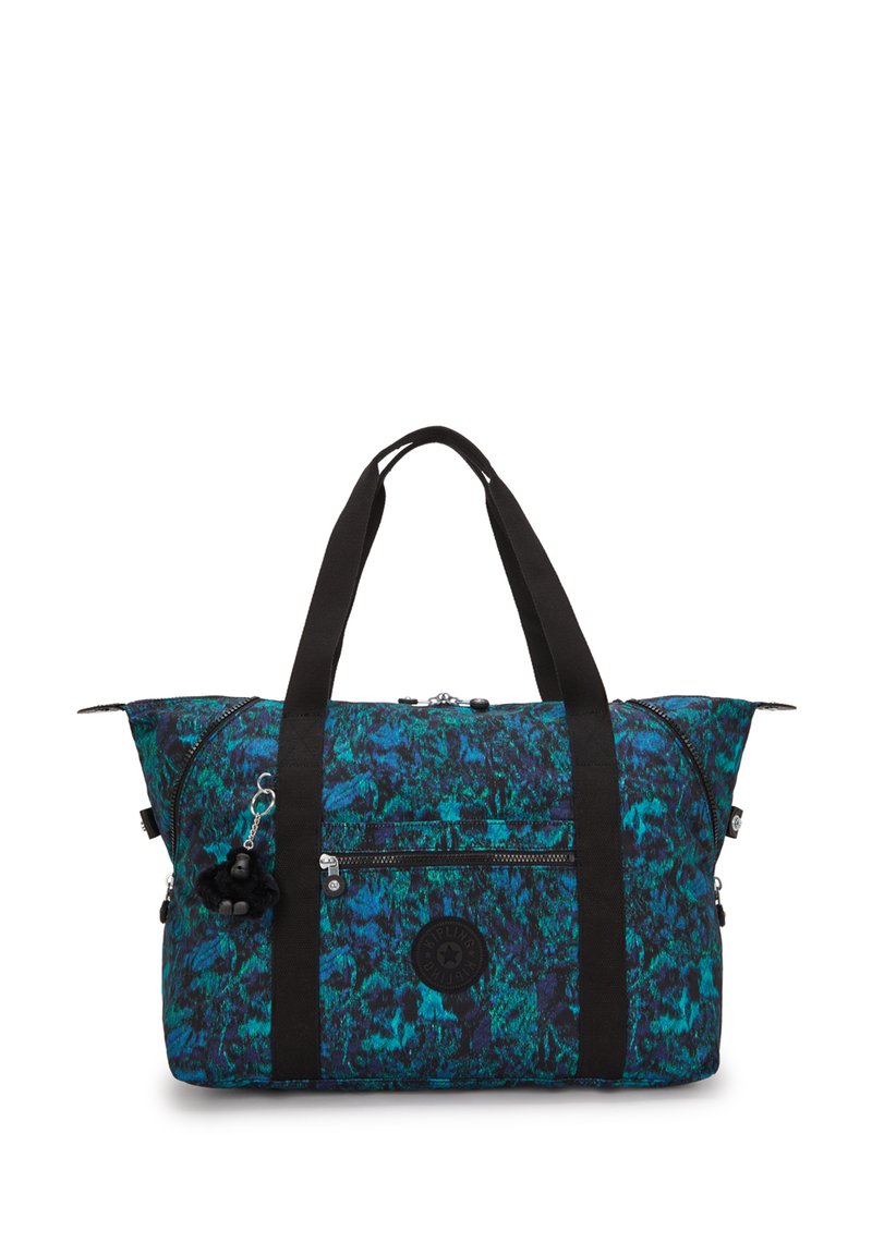 Rummelig duffelbag i blå og grøn abstrakt mønster, med sorte stofhanke, en frontlomme med lynlås, og en charms hængende fra en lynlås.