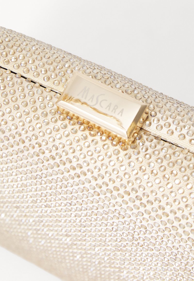 Pochette dorée avec une surface texturée ornée de petits clous brillants et un fermoir rectangulaire embossé avec "MASCARA."