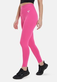 Prilagojene roza leggins hlače z visokim pasom in belim logotipom na bokih. Narejene iz raztegljivega materiala, ki se ponaša z gladko teksturo.