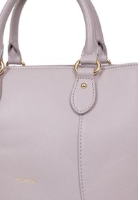 Borsa a mano di un delicato colore lavanda, realizzata in materiale sintetico testurizzato. Caratterizzata da accessori dorati, manici doppi e un accento centrale cucito.
