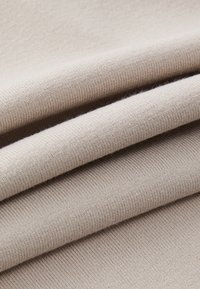 Beige kudumine, millel on peen soonikstruktuur, pakub pehmeid ja siledaks jäävaid voldikesi ning ühtlast mustrit kogu materjalis.