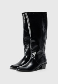 Cizme din piele negre, cu lungimea până la genunchi, cu vârf ascuțit și toc scăzut și masiv. Textură netedă, design structurat și detalii cu cusături centrale.