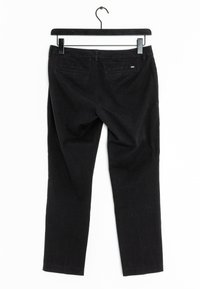 Svarta bomullsbukser hängande från en svart galge, med raka ben, två bakfickor och en subtil textur.