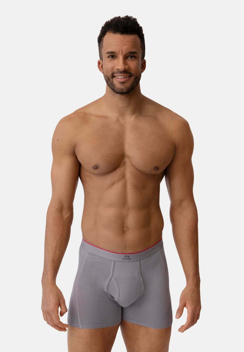 Grå boxershorts med en åtsittande design, med en rosa midjeband och subtila sömsdetaljer. Tyget verkar slätt och stretchy.
