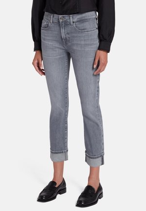 Lichtgrijze denim jeans met een rechte pasvorm, omgeslagen uiteinden, vijf zakken en een klassieke knoopsluiting. Gemaakt met zwarte instappers.