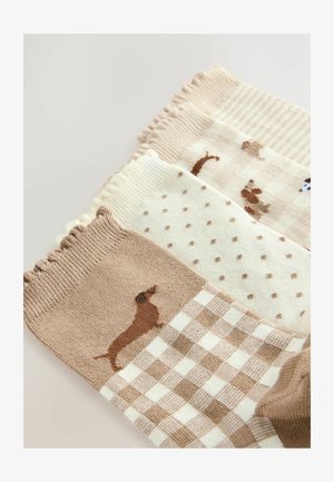 Drei Paar Socken in hellbraunen, weißen und cremefarbenen Tönen. Die Texturen umfassen gerippte und gemusterte Designs mit Dackelmotiven.