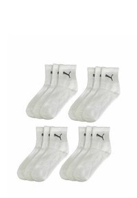 Weiße Sportsocken im Viererpack, mit gerippten Bündchen und schwarzen Puma-Logos auf jeder Socke. Glatte Textur, Standardcrew-Länge.