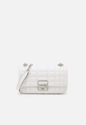 Sac à main en cuir matelassé blanc avec bandoulière chaîne argentée et fermoir rectangulaire argenté gravé du nom de la marque Michael Kors.
