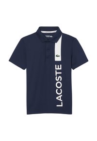 Granatowa koszulka polo z bawełny, z białym pionowym paskiem, na którym znajduje się napis "LACOSTE" oraz zielone logo krokodyla po lewej stronie.