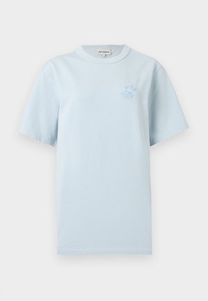 Svetlo modra majica s kratkimi rokavi z okroglim izrezom in majhnim modrim vezenim logotipom lisice na levi strani prsnega koša.