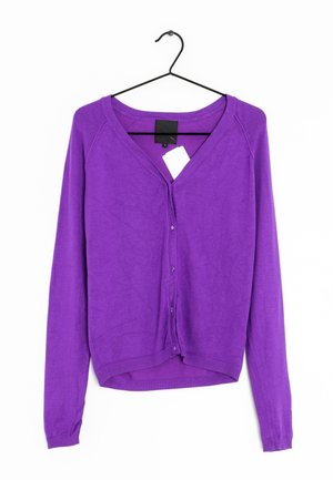 Cardigan en coton violet avec des manches longues, fermeture à boutons à l'avant, col en V et ourlet côtelé. Suspendu sur un cintre noir avec une étiquette.