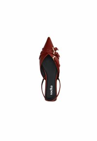 Chaussure slingback en cuir rouge à bout pointu avec des sangles croisées et trois boucles dorées. Semelle intérieure noire avec logo de marque blanc.