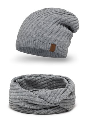 Grå ribbet strik beanie med foldet kant og et lædermærke; matchende grå infinity-scarf med en lignende ribbet tekstur og mønster.