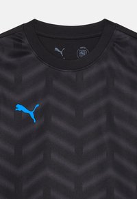 Juodas sportinis marškinėlis su tekstūruotu zigzaginiu raštu, apvaliu kaklu ir mėlynu Puma logotipu kairiajame krūtinės srityje.