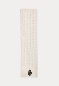 Sciarpa a maglia cable in color crema, con un bordo a costine e una patch logo nera. Il materiale sembra morbido e strutturato.