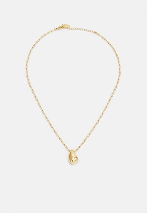 Collier en chaîne d'or délicat avec un petit pendentif lisse en forme de haricot sur un fond blanc uni.