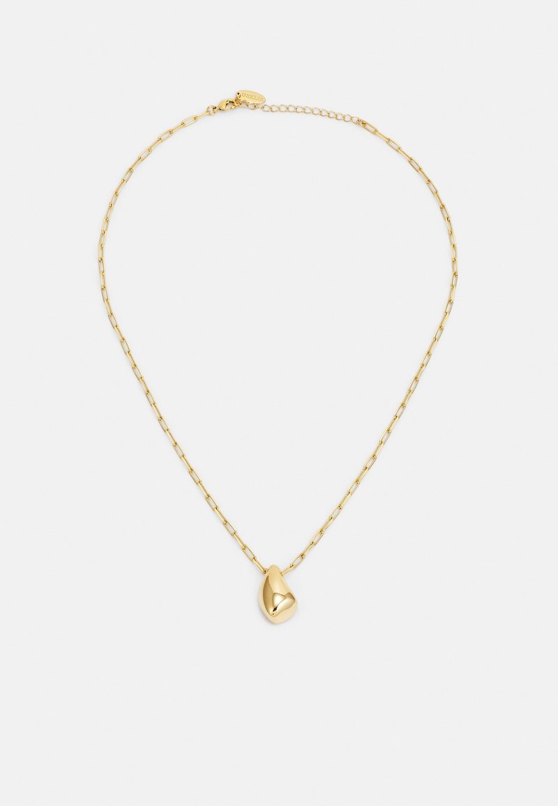 Collier en chaîne d'or délicat avec un petit pendentif lisse en forme de haricot sur un fond blanc uni.