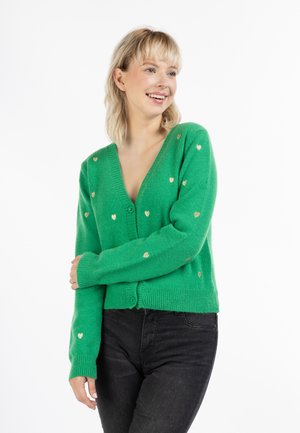 Cardigan verde cu un decolteu adânc în V, modele cu inimi aurii, manșete cu dungi și închidere cu nasturi. Fabricat dintr-un material moale, texturat.