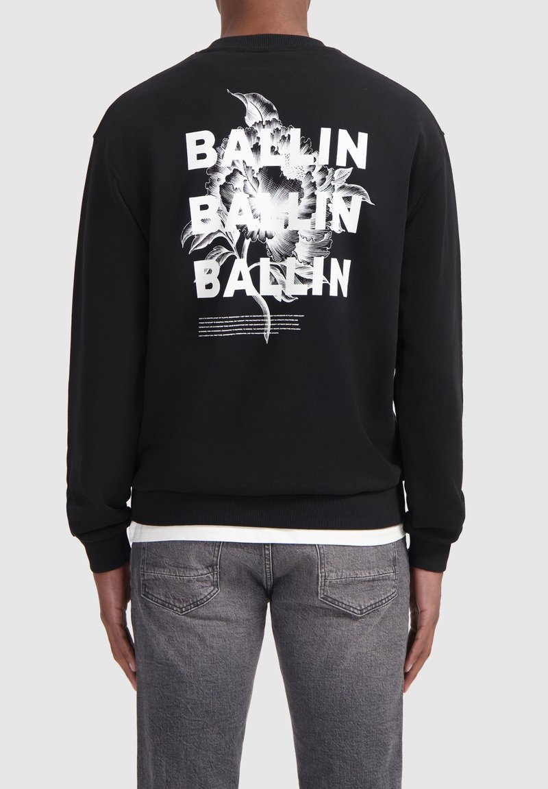 Zwarte sweatshirt met een bloemenpatroon en het woord "BALLIN" herhaald. De stof lijkt zacht, met ribgebreide manchetten en tailleband.