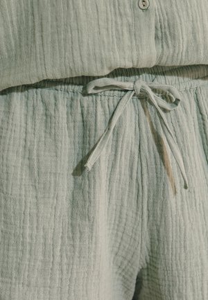 Pantaloni in tessuto strutturato verde chiaro con vita con coulisse annodata e top abbinato con dettaglio di bottoni sullo scollo.