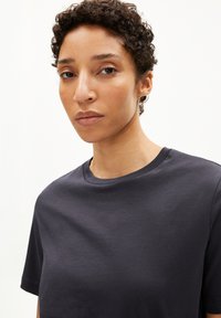 Donkergrijs katoenen T-shirt met een ronde hals en korte mouwen, voorzien van een gladde textuur en een minimalistisch ontwerp.