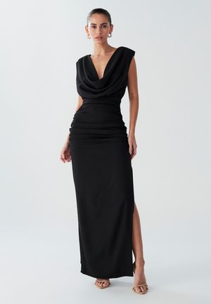 Black dress with a draped cowl neckline, cap sleeves, and ruched detailing along the waist. Features a side slit and smooth fabric texture.
