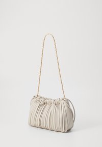 Pleated leather handbag in light beige with a gold chain strap. Features gathered top for a soft texture and rounded silhouette.
