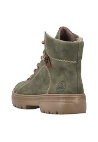 Bottines en daim vert avec un haut montant, lacées à l'avant, semelle en caoutchouc marron et surpiqûres contrastantes. Présente un logo sur le côté extérieur.