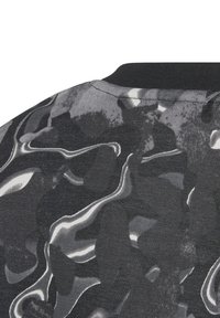 Tela abstracta en negro y gris con patrones fluidos, superficie texturizada y un cuello redondo negro.