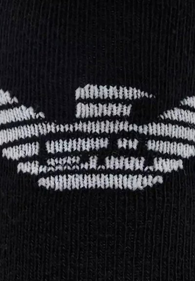 Chaussette en tissu noir avec un logo brodé blanc et des rayures horizontales, présentant un design géométrique distinctif.