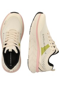 Scarpe da corsa in rete color crema chiaro con accenti verdi. Suola spessa avorio con tocchi di rosa e nero, caratterizzata da una superficie testurizzata.